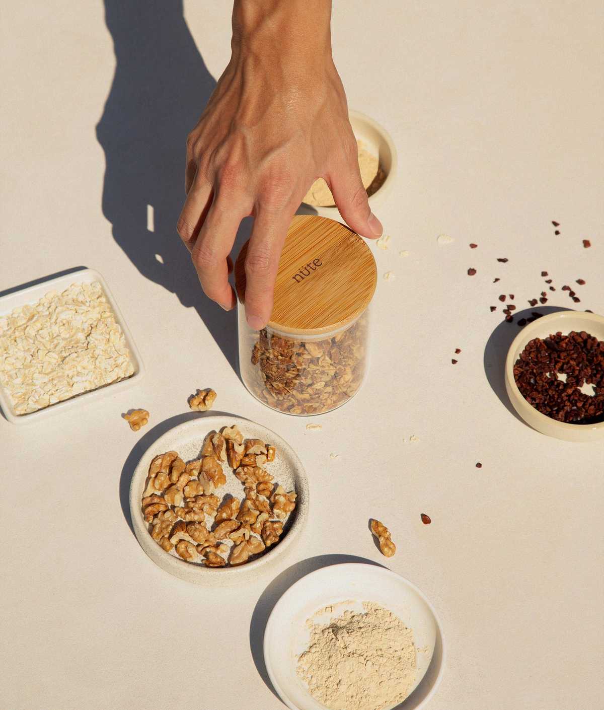 Hand grabbing a jar of granola